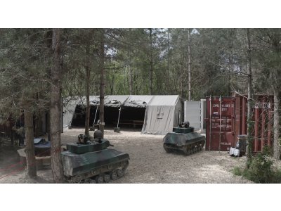 Un espace de restauration est installée sous une grande tente militaire.